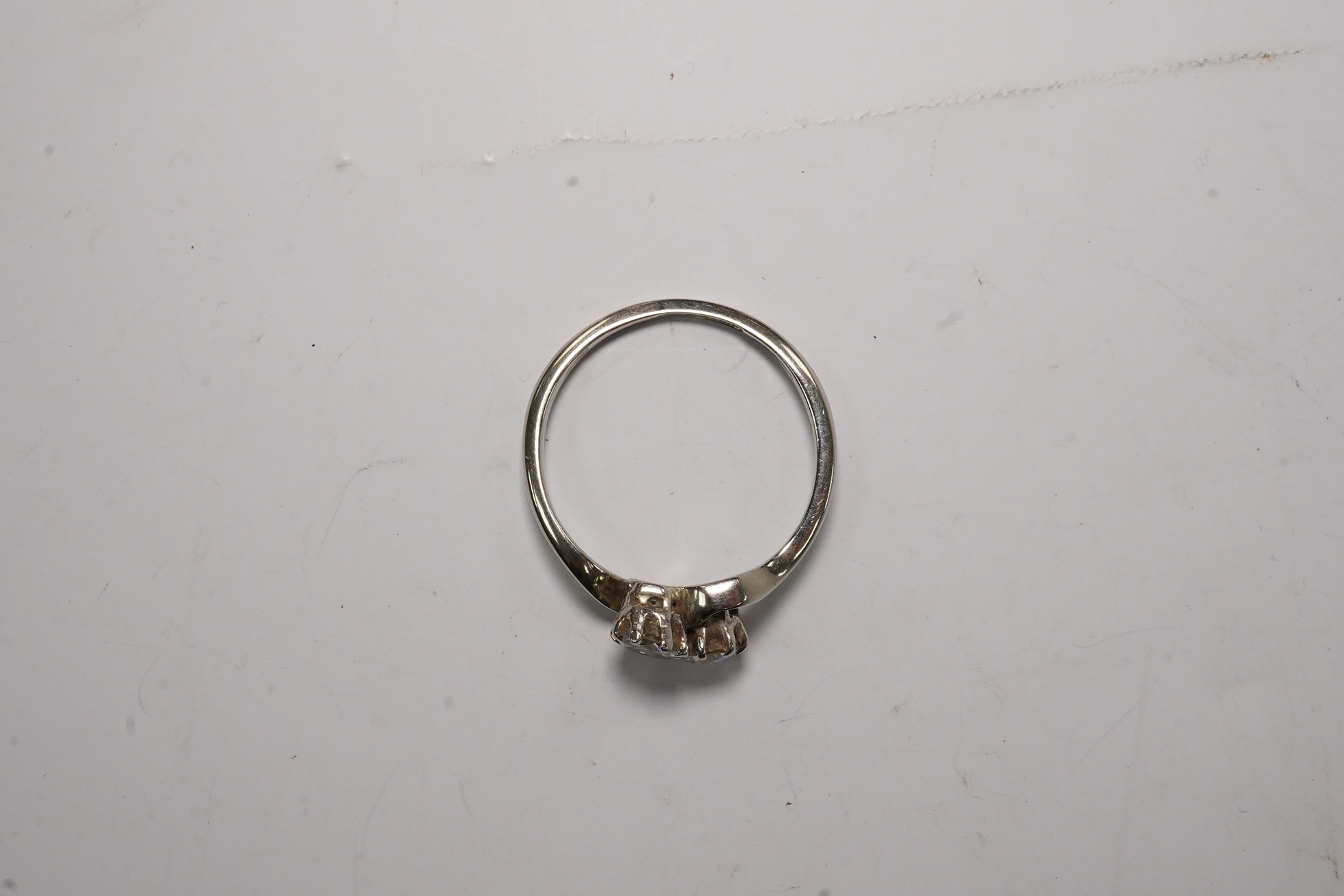 An 18ct, plat and two stone diamond set crossover ring, size O, gross weight 2.3 grams, Condition - fair to good
